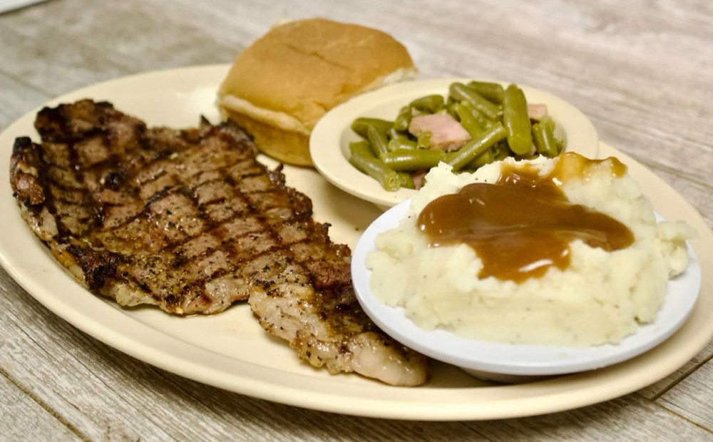 Grilled steak dinner with mashed potatoes, green beans and a roll